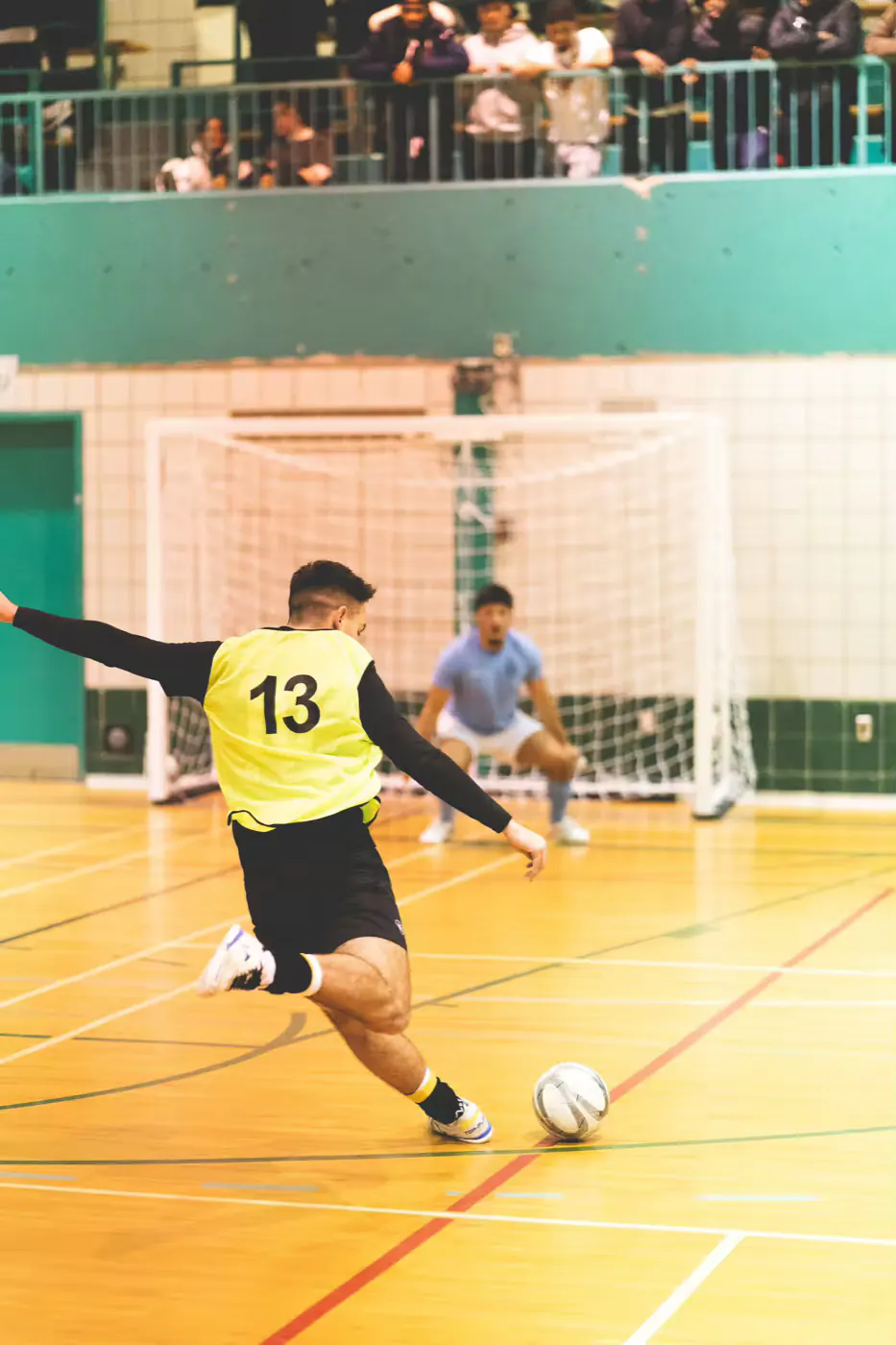 Futsal player striking the ball on indoor turf